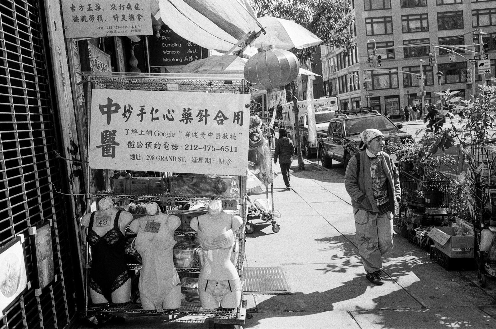 Black-and-white street photograph of a Chinatown storefront with Chinese signage, New York City