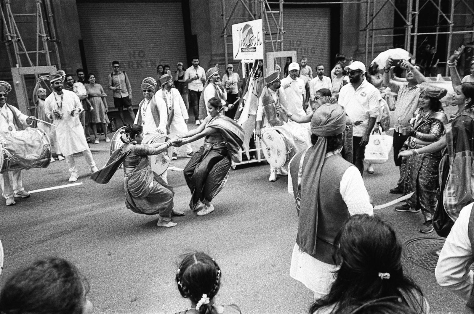 Parade dancers in traditional dress on a Queens street, black-and-white street photograph