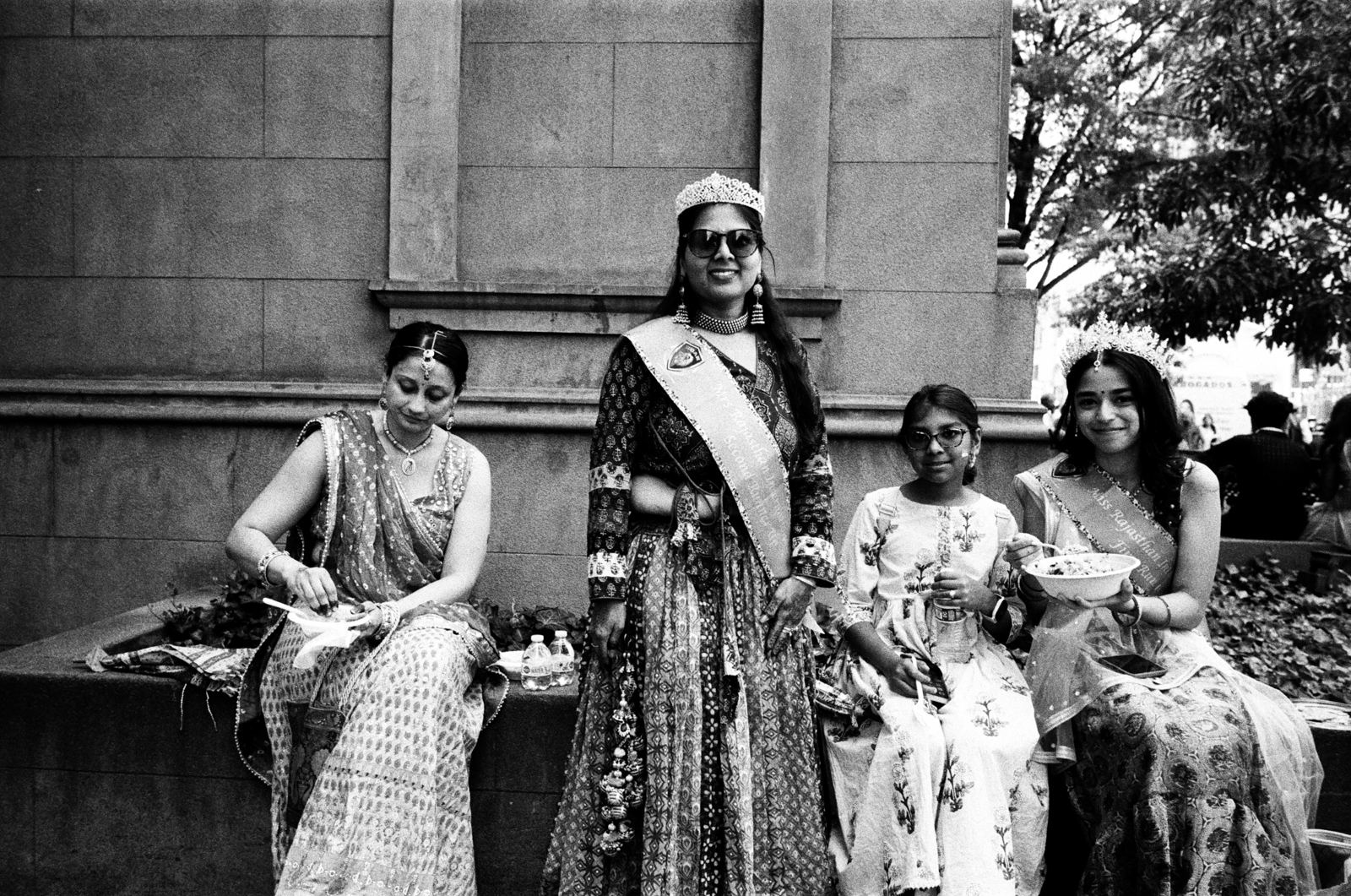 Women in saris seated on stone steps, black-and-white street portrait, New York City